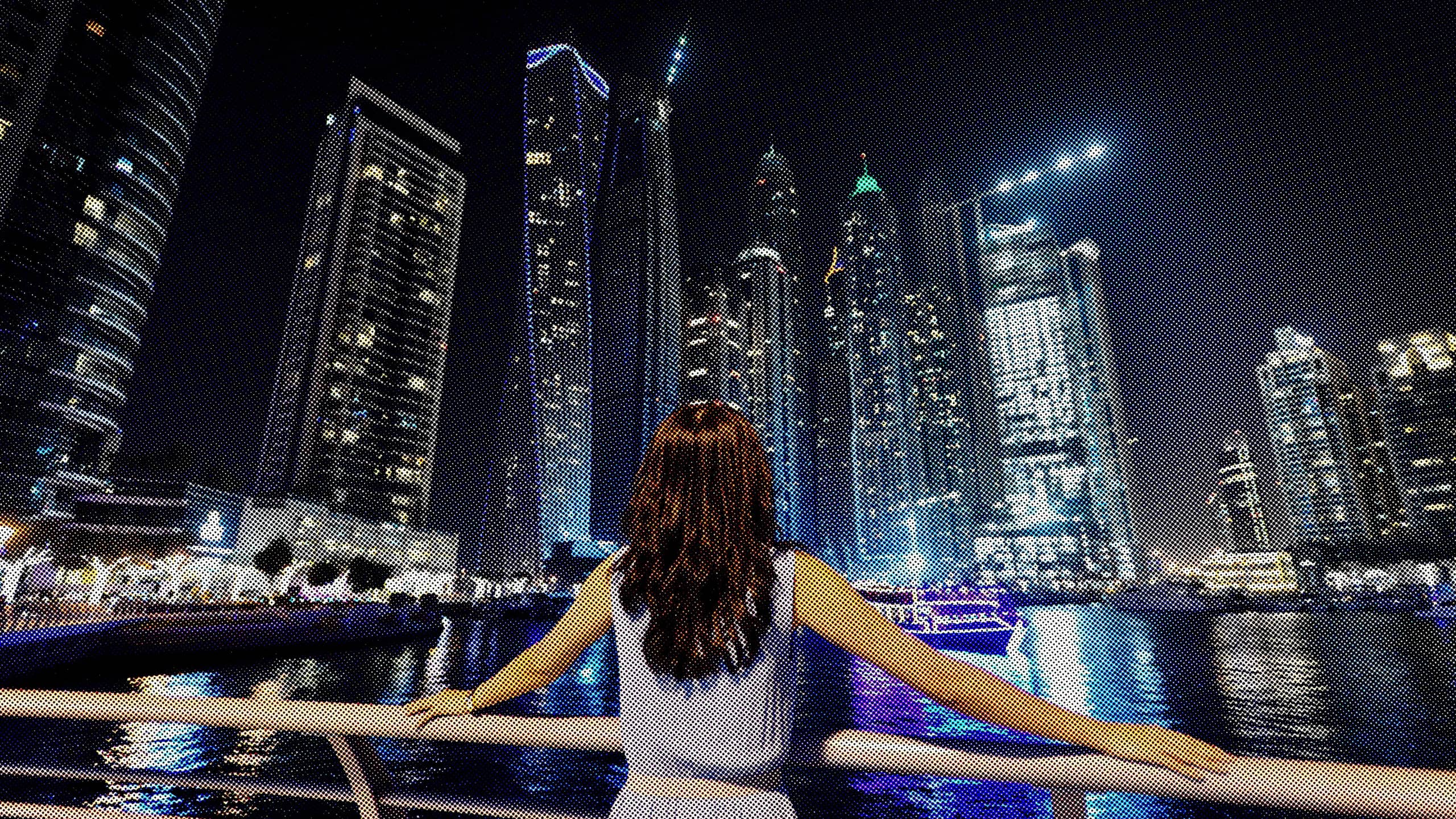 woman looks out at Dubai skyline at night