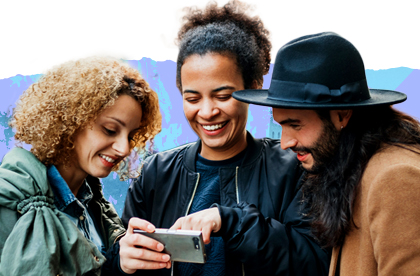 Two women and a man looking at a phone together and laughing